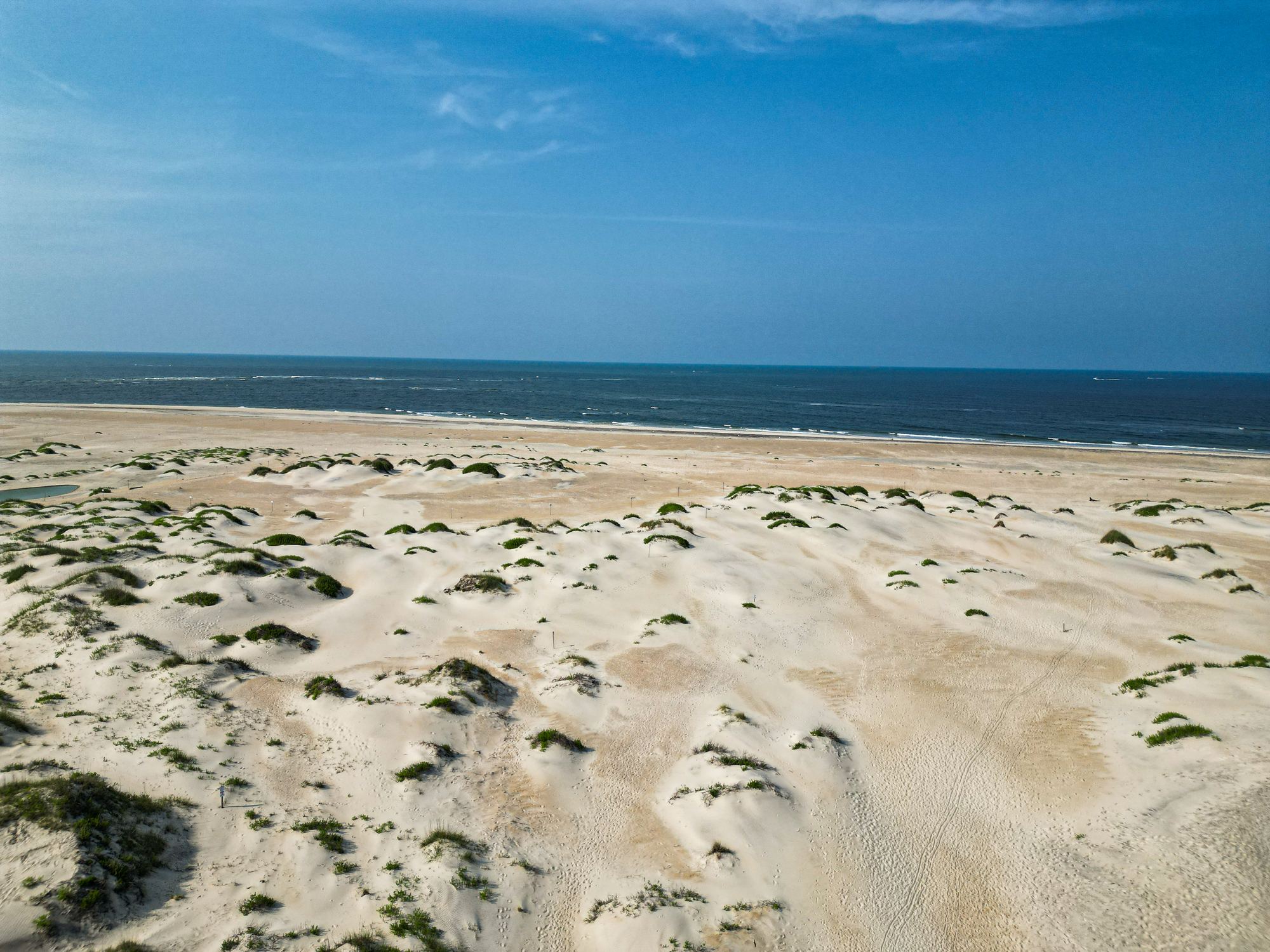 Aerial view of white sand dunes meeting the Atlantic