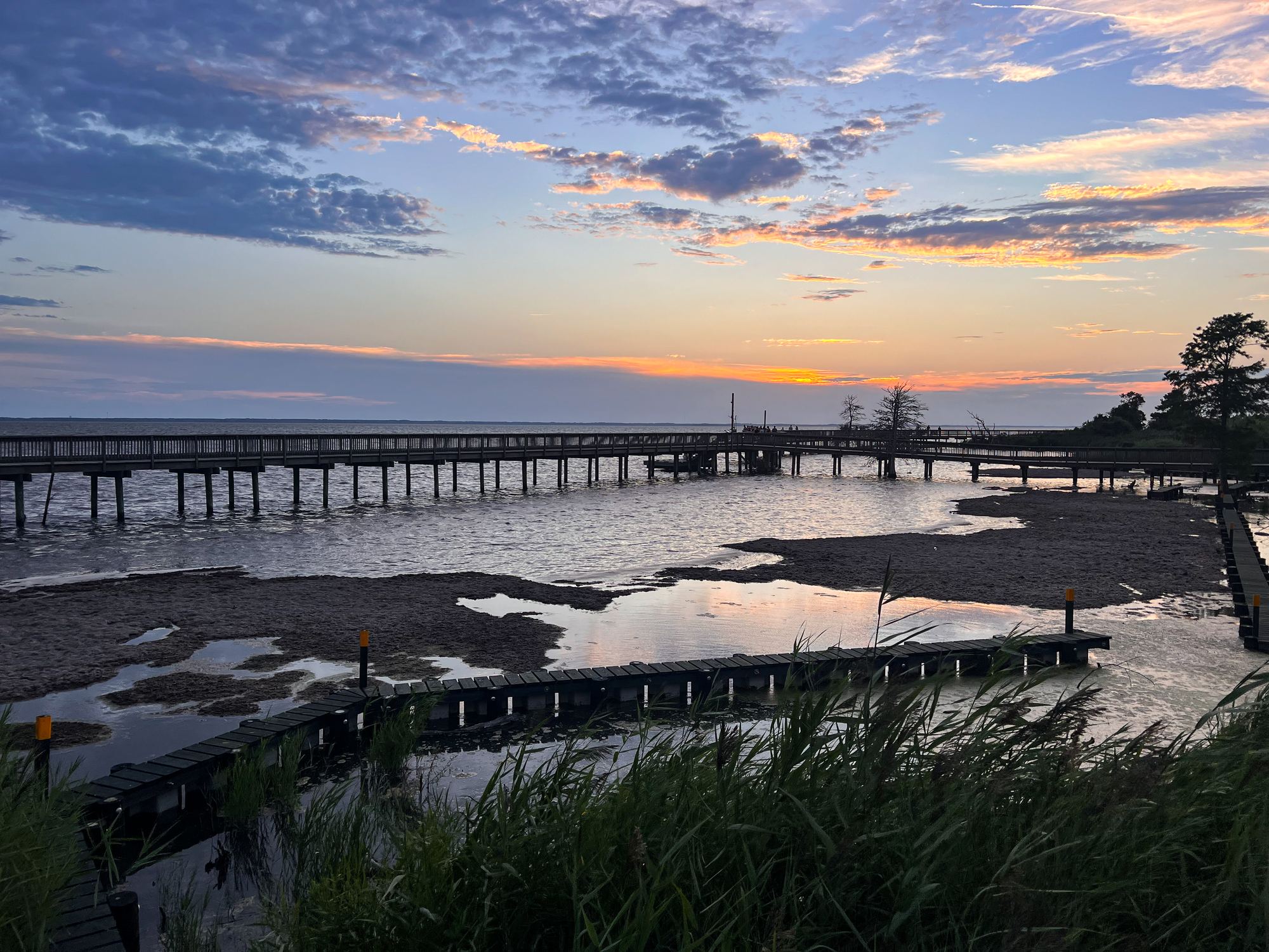 Wooden boardwalk over the sound at sunset